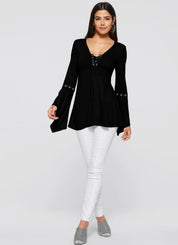 Donna con tunica nera a maniche lunghe e pantaloni bianchi. Moda femminile elegante, abbigliamento casual chic, outfit autunnale.