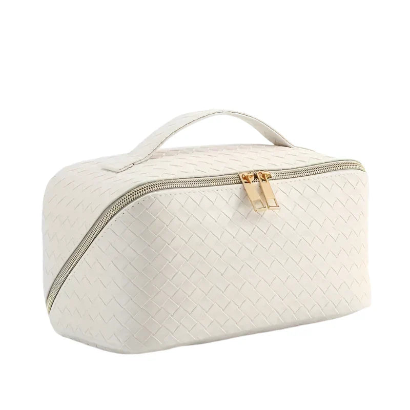 Astuccio da viaggio in pelle intrecciata bianca con cerniera dorata e manico superiore. Elegante e pratico per cosmetici e accessori.