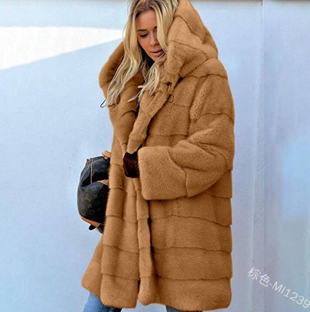 Donna con cappotto in pelliccia sintetica marrone, cappuccio ampio, tasche laterali. Moda invernale, abbigliamento caldo, stile casual chic.