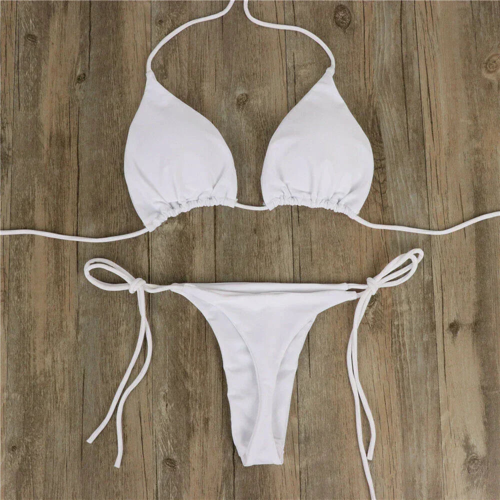 Bikini bianco a triangolo su sfondo in legno, costume da bagno estivo, due pezzi con laccetti regolabili, moda mare donna.