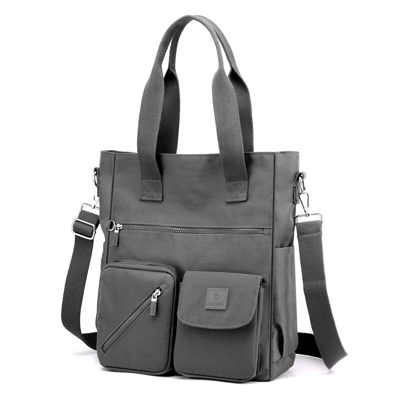 Borsa a tracolla grigia in tessuto impermeabile con tasche multiple, manici resistenti e tracolla regolabile. Design moderno e funzionale.