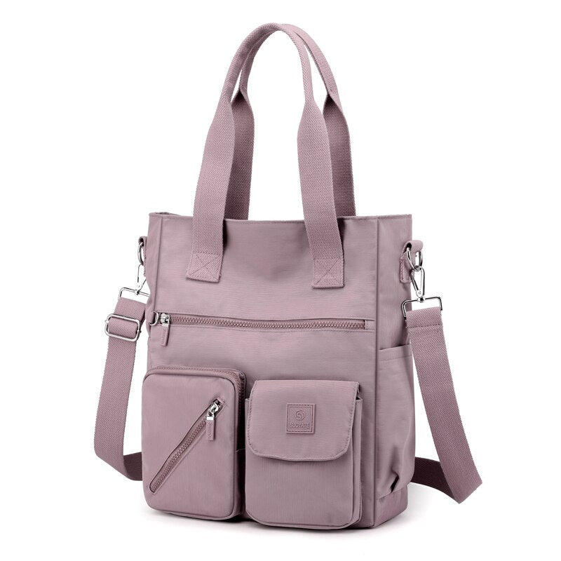 Borsa a tracolla in nylon rosa con tasche multiple, manici resistenti e tracolla regolabile. Design moderno e funzionale per donna.