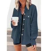 Donna con camicia blu scuro a coste, bottoni dorati, tiene una tazza bianca. Moda casual femminile, abbigliamento autunnale, stile urbano.