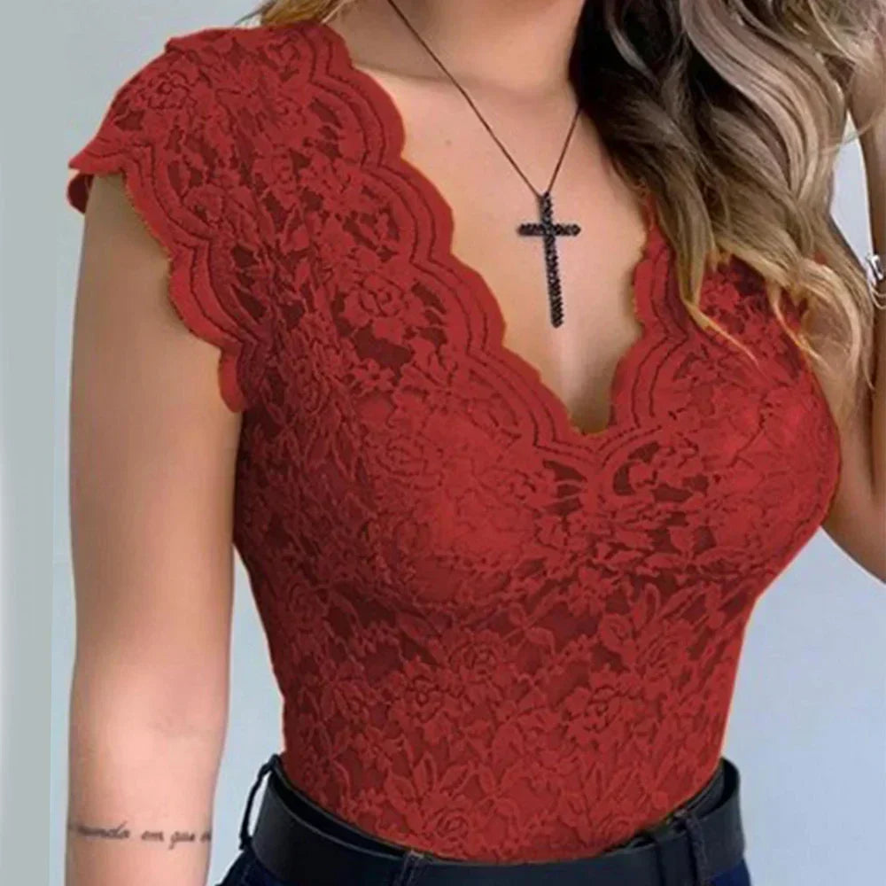 Blusa in pizzo rosso con scollo a V e maniche corte, indossata con collana a croce. Elegante top femminile, ideale per occasioni speciali.