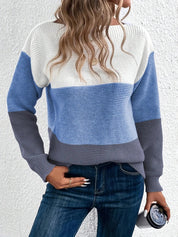 Maglione a righe blu, bianco e grigio, donna di spalle, capelli ondulati, jeans blu, sfondo bianco. Moda casual autunnale, stile moderno.