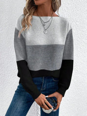 Maglione donna a righe grigie e nere, maniche lunghe, abbinato a jeans blu. Stile casual, perfetto per l'autunno.