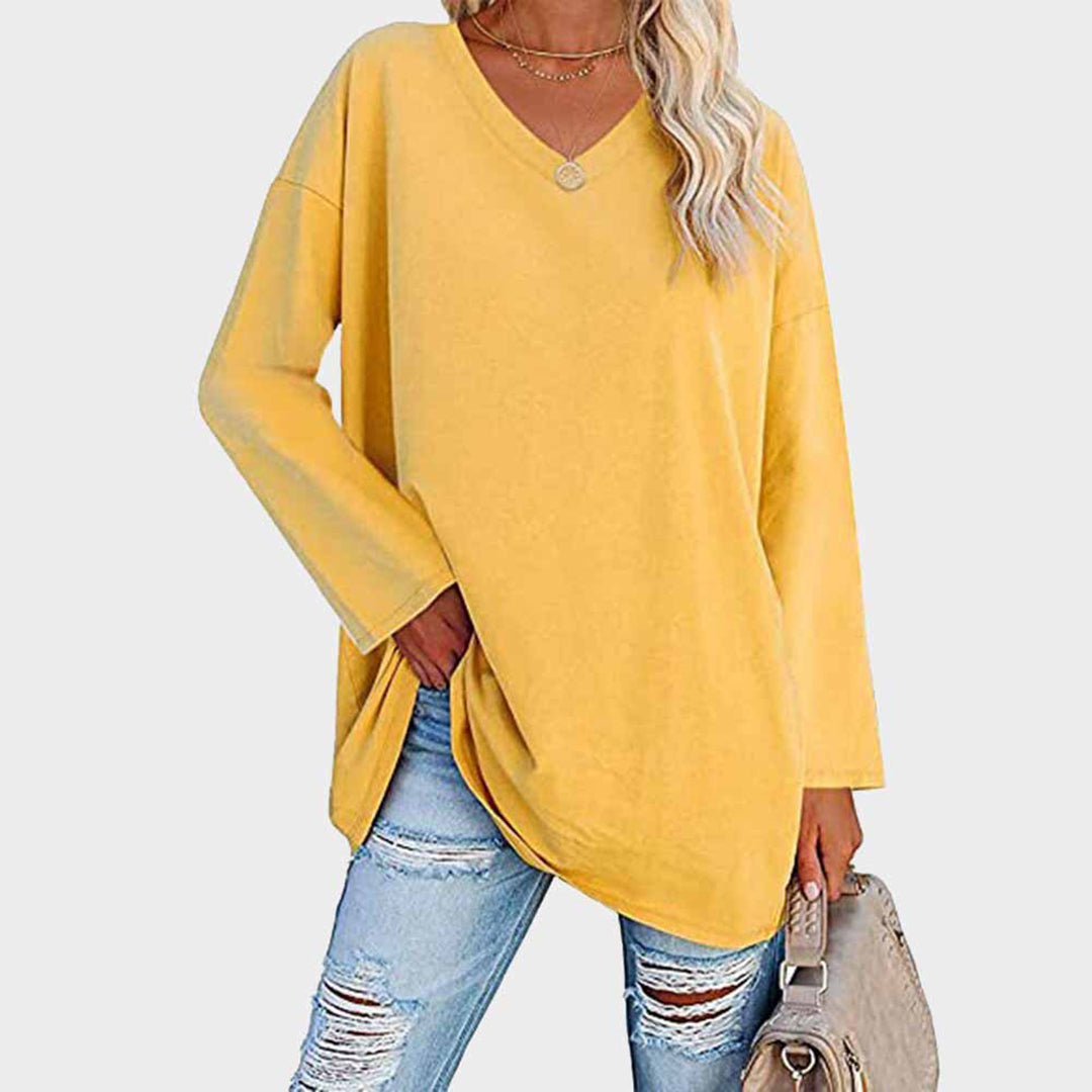Maglia oversize gialla da donna, maniche lunghe, scollo a V, abbinata a jeans strappati. Stile casual, moda autunnale, abbigliamento femminile trendy.