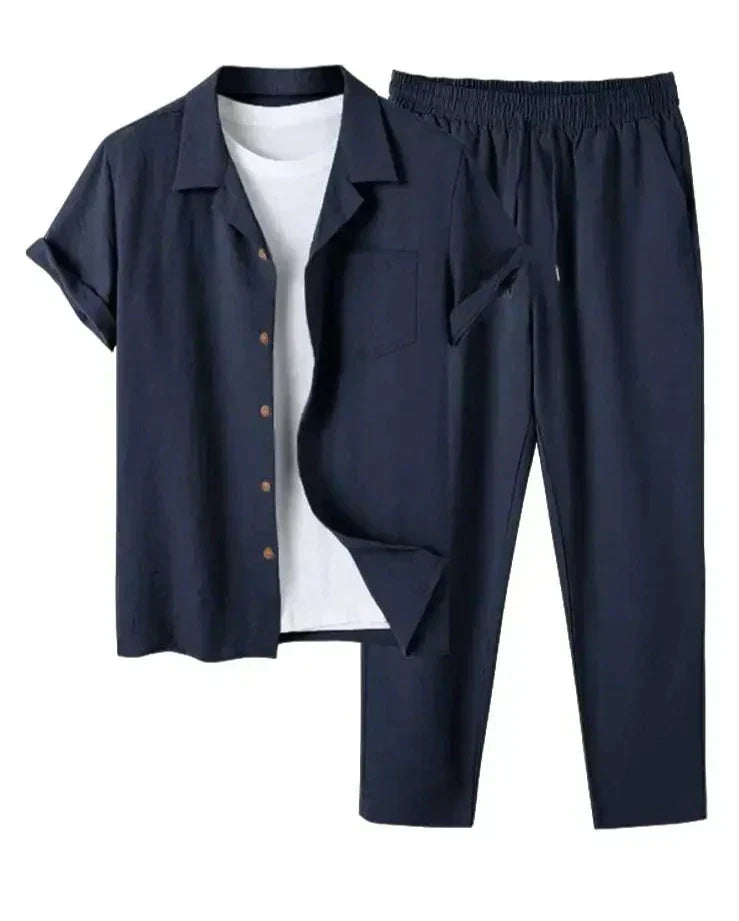 Completo uomo estivo in lino blu scuro, camicia a maniche corte con bottoni e pantaloni elasticizzati, ideale per look casual e freschi.
