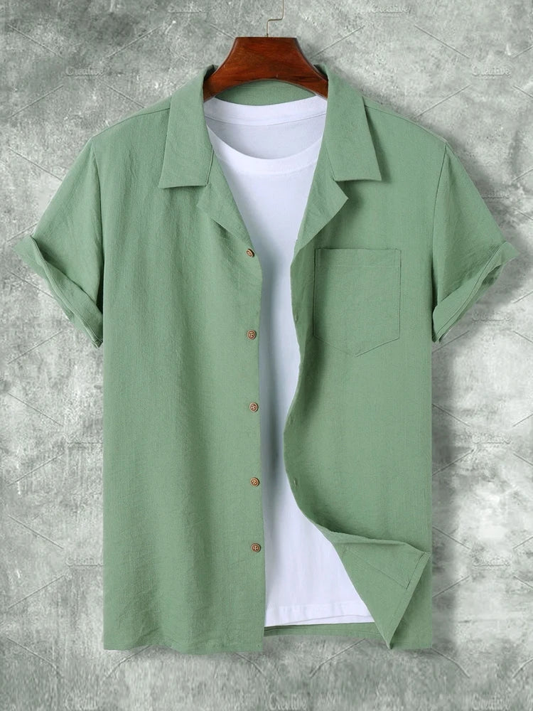 Camicia verde chiaro da uomo in lino, maniche corte, con colletto classico e taschino, su sfondo grigio. Stile casual estivo.