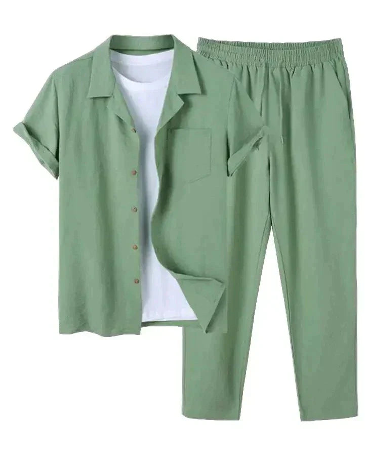 Completo estivo uomo verde salvia, camicia a maniche corte con bottoni e pantaloni elastici, abbinato a t-shirt bianca. Moda casual elegante.