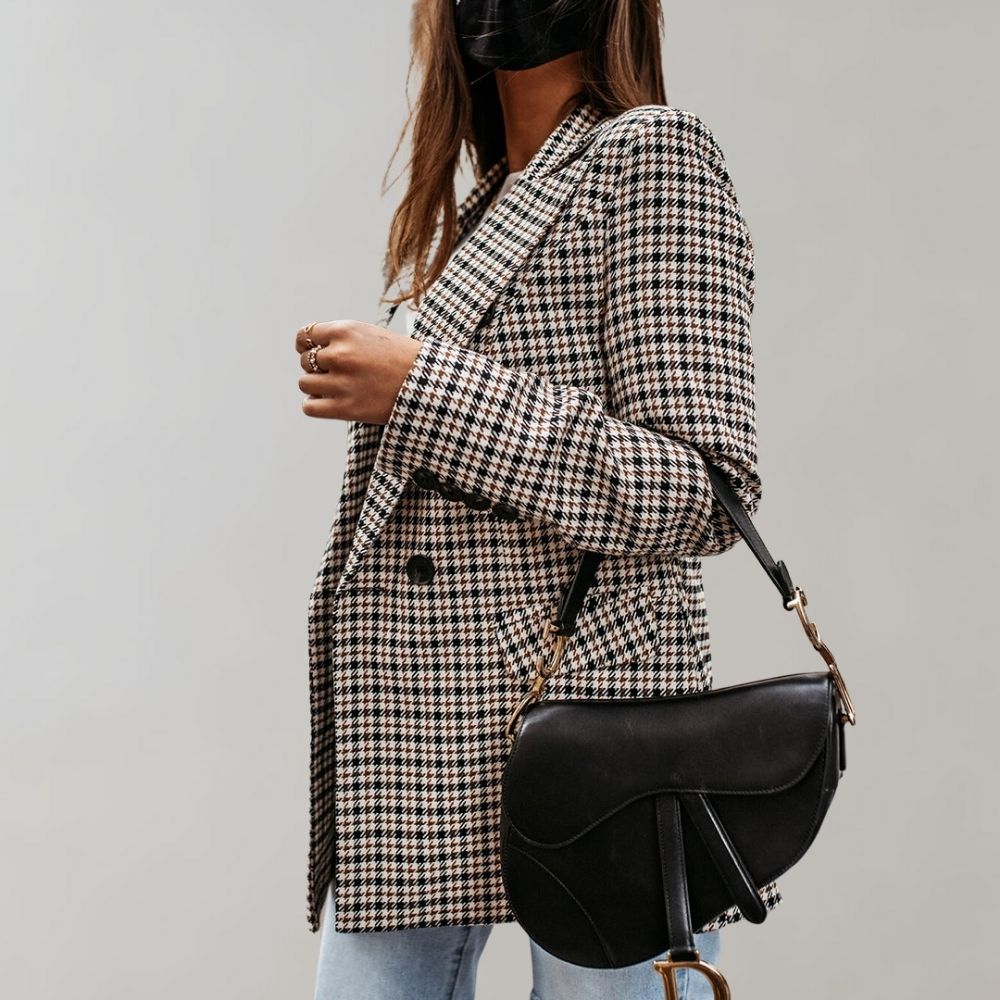Giacca a quadri donna elegante, abbinata a borsa nera a tracolla. Moda autunnale, stile casual chic. Perfetta per look quotidiani.