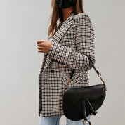Giacca a quadri donna elegante, abbinata a borsa nera a tracolla. Moda autunnale, stile casual chic. Perfetta per look quotidiani.