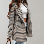 Donna con cappotto a quadri pied de poule, t-shirt bianca e jeans chiari. Moda autunnale elegante, abbigliamento casual chic.