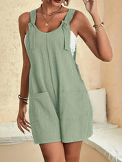Vestito estivo verde salvia, senza maniche, con tasche frontali e dettagli a fiocco. Ideale per look casual e freschi. Moda donna estiva.