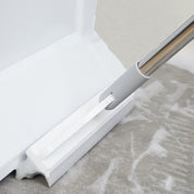 Scopa tergipavimento bianca con manico in acciaio inox, pulizia pavimenti bagnati, ideale per bagno e cucina, accessorio domestico essenziale.