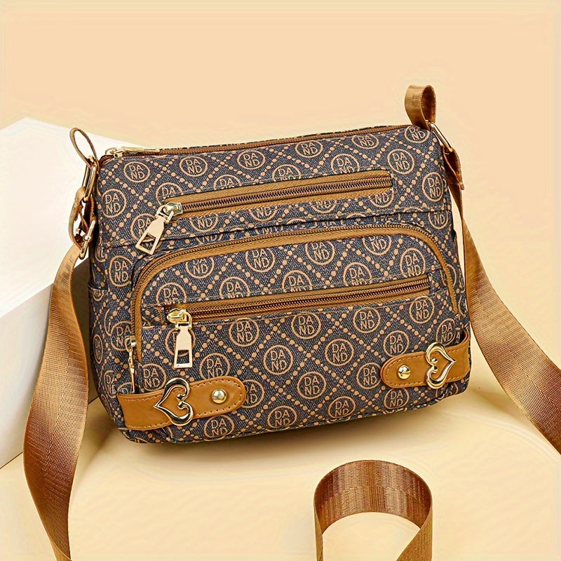 Borsa a tracolla marrone con motivo monogramma, cerniere dorate e dettagli in pelle. Elegante accessorio moda donna, perfetto per ogni occasione.