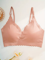 Reggiseno senza cuciture rosa, design a triangolo, spalline regolabili, bordo ondulato. Intimo comodo e moderno per donna.