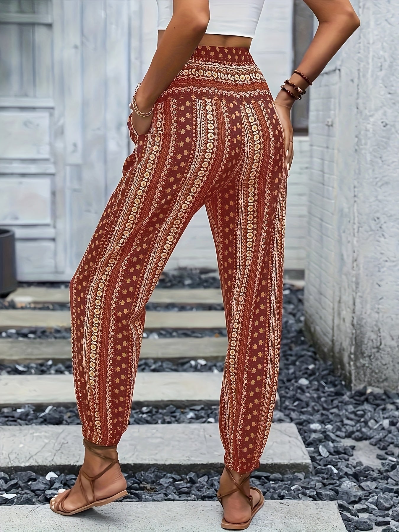 Pantaloni boho a vita alta con stampa etnica, donna di spalle, top bianco, sandali marroni, moda estiva casual, stile bohemien.