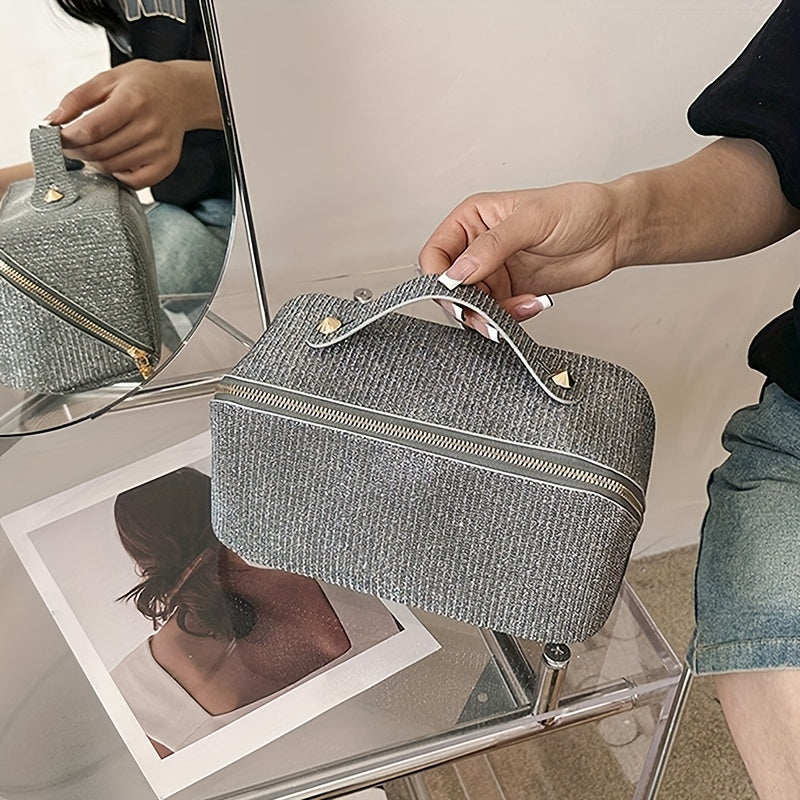 Borsa cosmetica grigia con manico, design elegante, su sedia trasparente. Ideale per viaggi, organizzazione trucco. Accessorio moda pratico e chic.