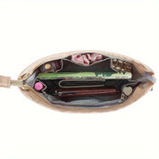 Interno di una borsa beige con scomparti organizzati, contenente un libro, penne, rossetto e accessori. Design elegante e funzionale per donne moderne.