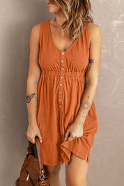 Donna con abito estivo arancione, bottoni frontali, tatuaggi visibili, borsa marrone. Moda casual femminile, abbigliamento estivo trendy.