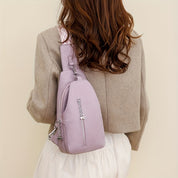 Donna con zaino a tracolla lilla in pelle, giacca beige e abito bianco. Moda femminile, accessori eleganti, stile casual chic.