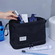 Borsa da viaggio nera con prodotti per la cura personale: flaconi blu, dentifricio e spazzolino. Ideale per organizzare accessori da bagno.