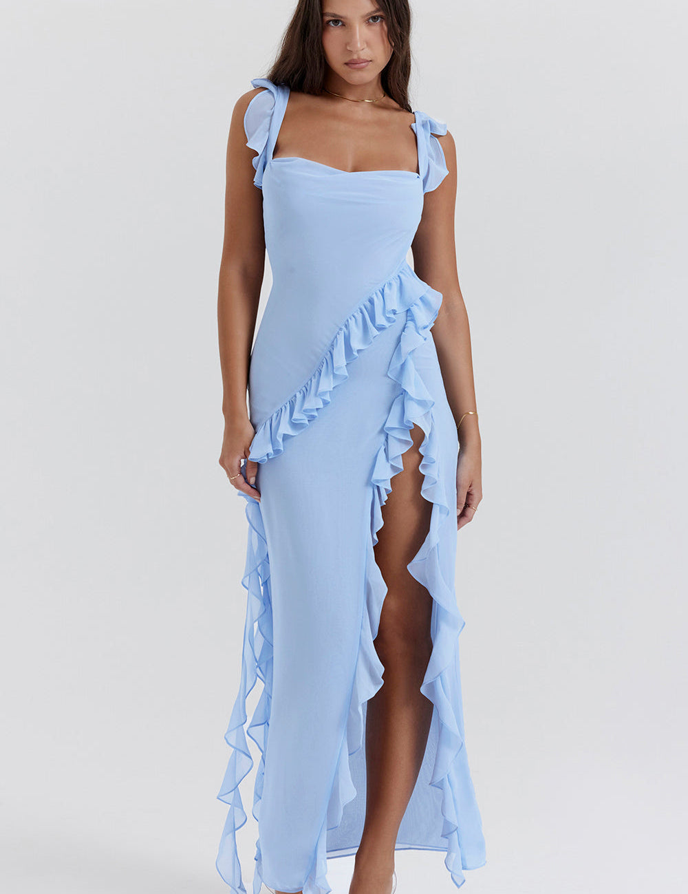Abito lungo azzurro con balze, spacco laterale e spalline larghe. Elegante e moderno, ideale per eventi estivi e cerimonie.