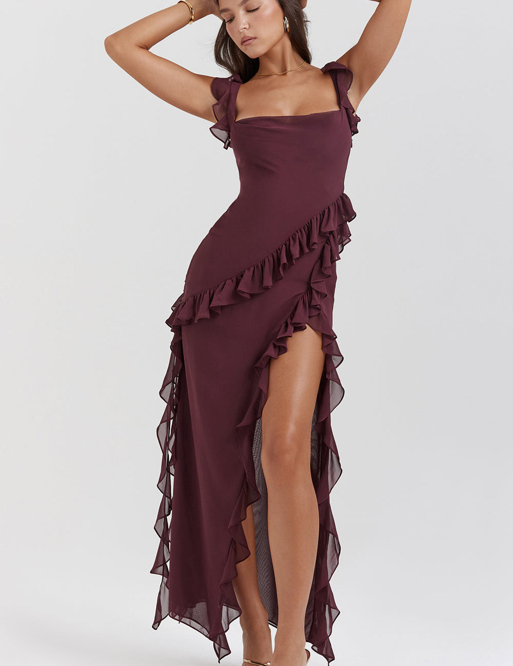 Abito lungo elegante bordeaux con balze, spalline sottili e spacco laterale. Perfetto per eventi serali e cerimonie. Moda donna sofisticata.
