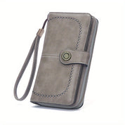 Portafoglio donna in pelle grigia con cinturino, design elegante con chiusura a bottone decorativa, ideale per moda e accessori femminili.