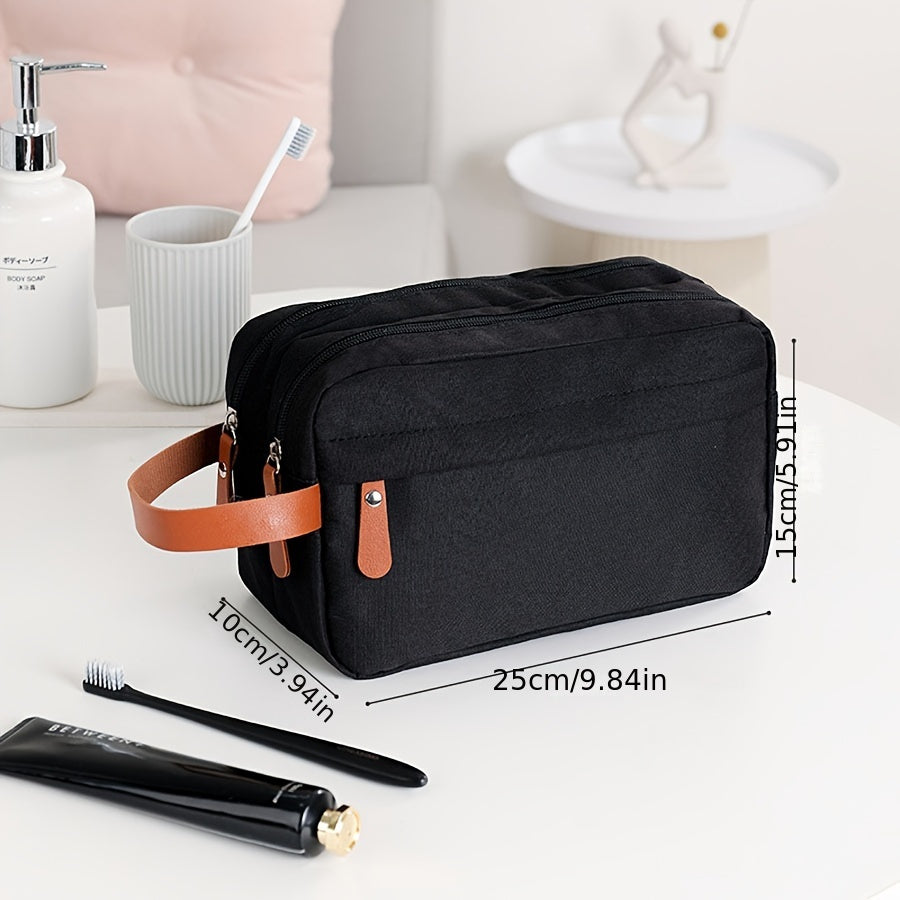Borsa da toilette nera con manico in pelle marrone, dimensioni 25x15x10 cm, su tavolo da bagno con spazzolino, dentifricio e dispenser sapone.