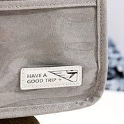 Borsa da viaggio grigia con etichetta "Have a Good Trip", design elegante, ideale per viaggiatori. Accessorio pratico e alla moda.