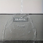 Valigia impermeabile grigia con etichetta "TRAVEL", resistente all'acqua, ideale per viaggi, protezione bagagli, design robusto e moderno.