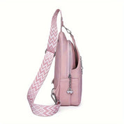 Zaino rosa in pelle con tracolla regolabile a motivo geometrico, tasca frontale con zip e ciondolo decorativo. Accessorio moda donna elegante.