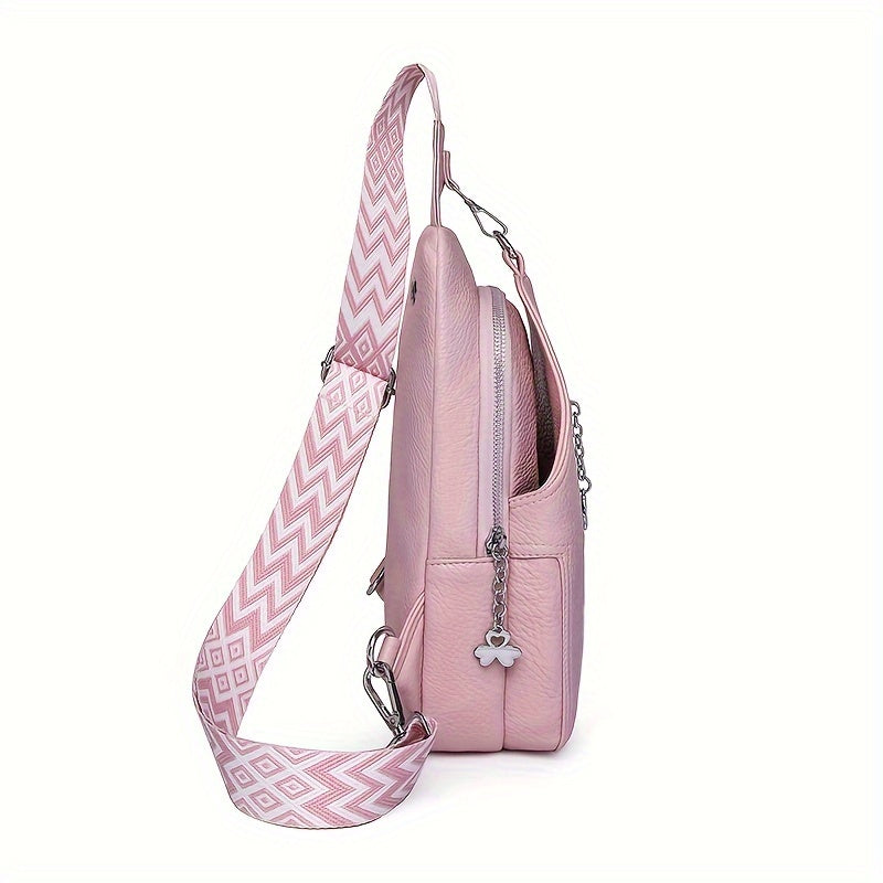 Zaino rosa in pelle con tracolla regolabile a motivo geometrico, tasca frontale con zip e ciondolo decorativo. Accessorio moda donna elegante.