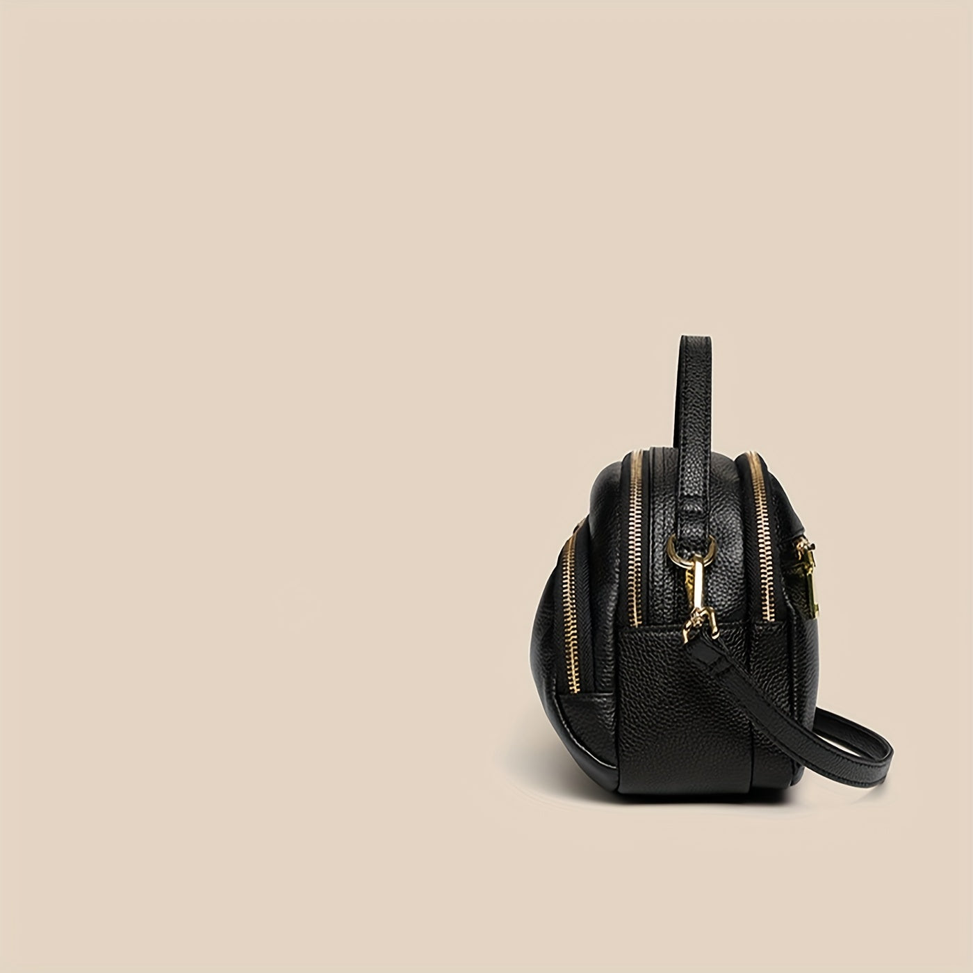 Elegante borsa a tracolla in pelle nera con doppia cerniera dorata, design compatto e moderno. Accessorio moda donna, ideale per ogni occasione.