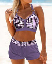 Costume da bagno donna due pezzi, top a righe viola e pantaloncini coordinati, spiaggia estiva, moda mare, abbigliamento femminile trendy.