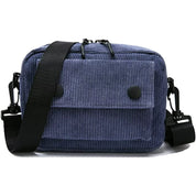 Borsa a tracolla in velluto a coste blu con tasca frontale e chiusura a bottoni, tracolla regolabile nera, stile casual e pratico per uso quotidiano.