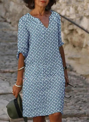 Abito estivo donna, motivo geometrico blu e bianco, maniche a tre quarti, scollo a V, stile casual, perfetto per passeggiate estive.