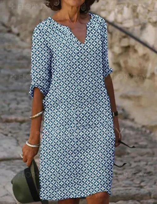 Abito estivo donna, motivo geometrico blu e bianco, maniche a tre quarti, scollo a V, stile casual, perfetto per passeggiate estive.