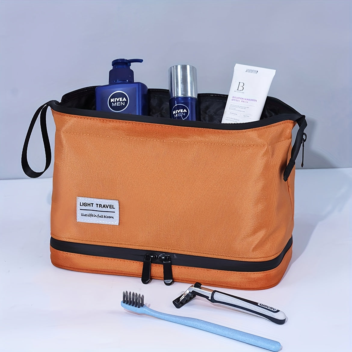 Borsa da toilette arancione con prodotti per la cura personale: crema Nivea, spray, crema viso e spazzolino. Ideale per viaggi e organizzazione.