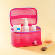 Astuccio da viaggio rosa trasparente con prodotti cosmetici, flaconi e tubetti. Ideale per organizzare articoli da toeletta. Accessorio da bagno pratico.