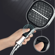 Doccia a mano quadrata nera con ugelli anticalcare, impugnatura ergonomica e pulsante di controllo. Design moderno per bagno elegante.
