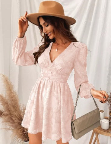 Donna con abito rosa in pizzo, cappello beige, borsa a tracolla, sfondo bianco. Moda femminile elegante, abbigliamento casual chic.