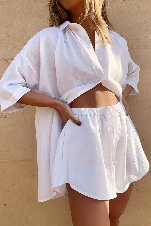 Donna con camicia bianca oversize e shorts coordinati in lino, moda estiva casual, abbigliamento leggero e traspirante, stile rilassato.