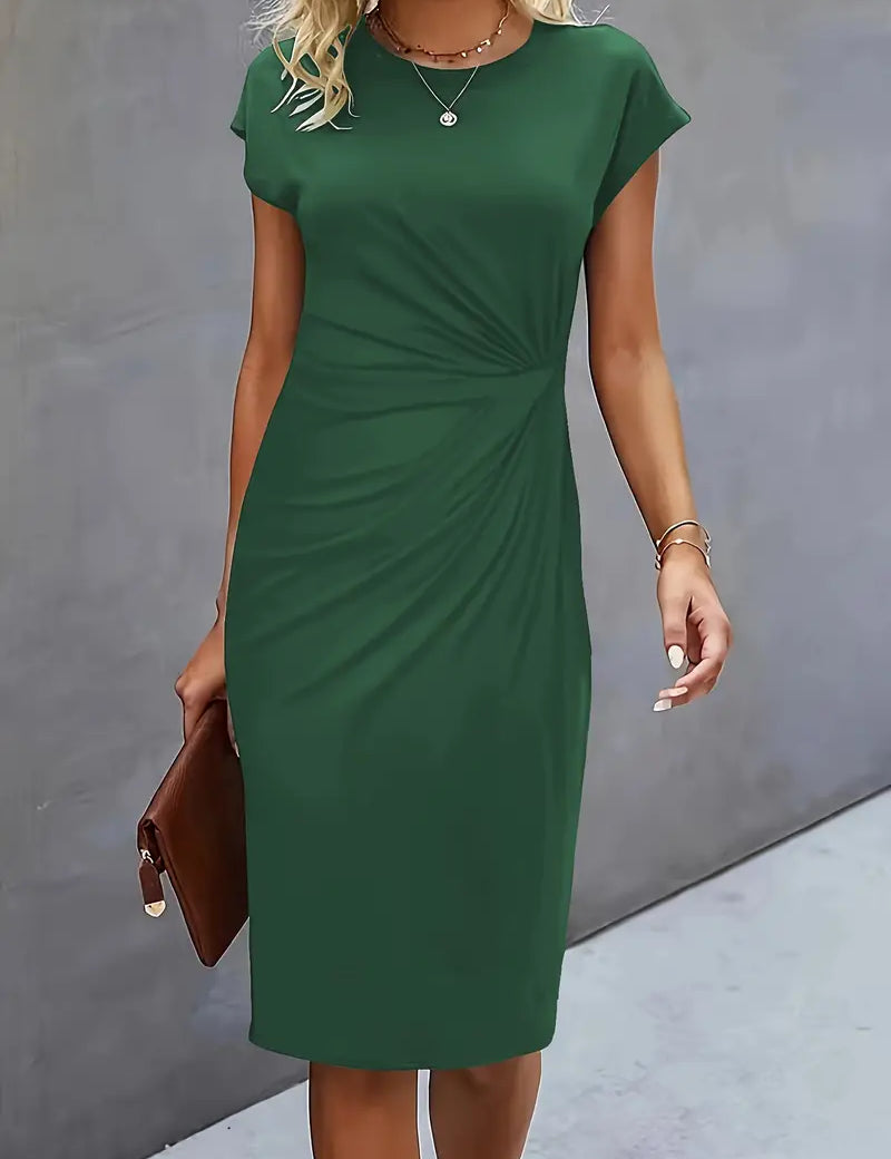 Abito verde elegante da donna, maniche corte, lunghezza al ginocchio, adatto per occasioni formali. Accessori: borsa marrone, gioielli discreti.