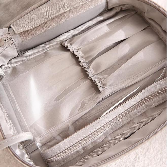 Borsa organizer da viaggio beige con tasche trasparenti e scomparti multipli, ideale per cosmetici e accessori. Design elegante e funzionale.