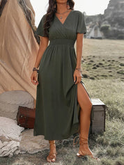 Abito lungo verde oliva con spacco laterale, scollo a V e maniche corte, indossato all'aperto. Perfetto per moda estiva e look casual chic.