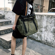 Donna con borsa a tracolla verde militare, design urbano, tasche multiple, stile casual. Perfetta per viaggi e uso quotidiano.