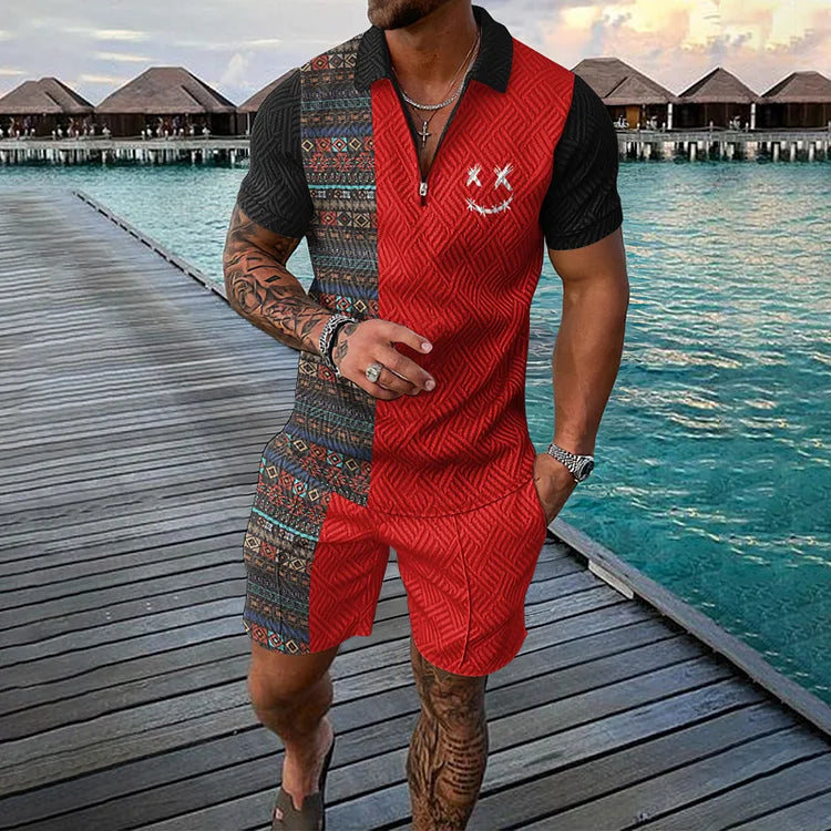 Uomo con tuta estiva rossa e nera a motivi geometrici, su passerella di legno vicino al mare. Moda estiva, abbigliamento casual maschile.